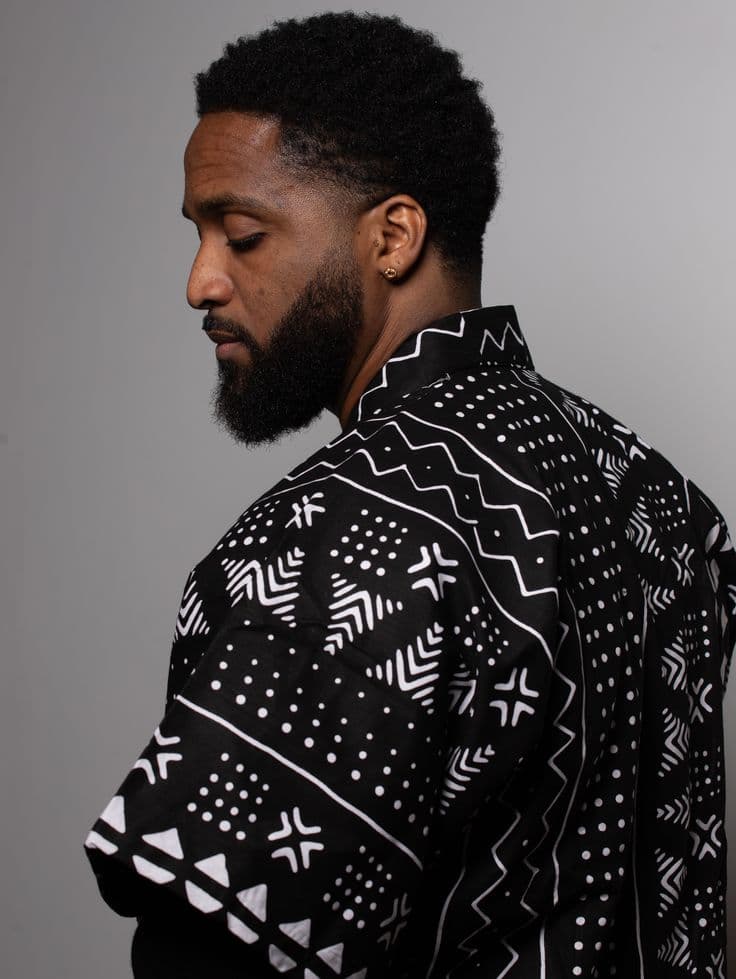 A model in profile wearing a black-and-white geometric print shirt